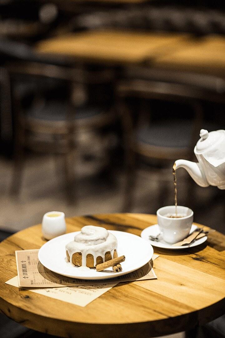 A slice of cake and a teapot on a wooden table
