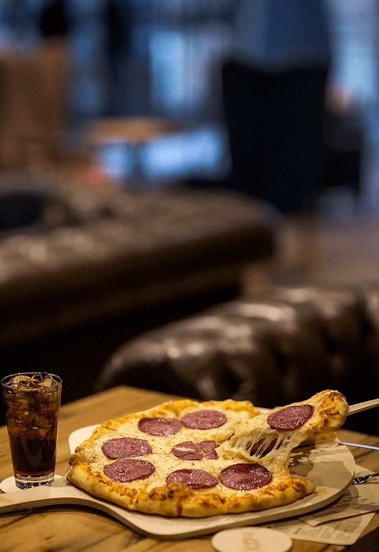 A salami pizza on a wooden board