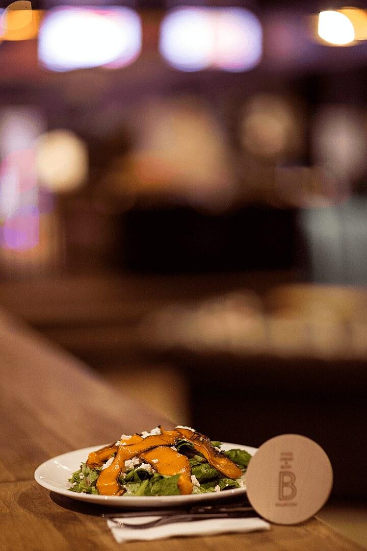 A salad on the bar counter with the lane screens behind